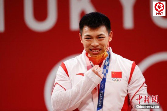 北京时间7月25日晚,在东京奥运会男子举重67公斤级比赛中,中国选手谌利军以抓举145公斤、挺举187公斤、总成绩332公斤夺冠,打破挺举和总成绩奥运纪录的同时,也为中国体育代表团摘得本届奥运会的第六金。图为谌利军在颁奖仪式上摘下口罩。 <a target='_blank' data-cke-saved-href='http://www.chinanews.com/' href='http://www.chinanews.com/'><p align=